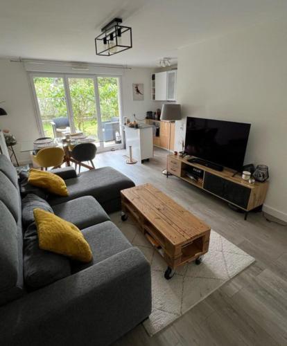un salon avec un canapé et une table basse dans l'établissement Paris's appartement, à Gennevilliers