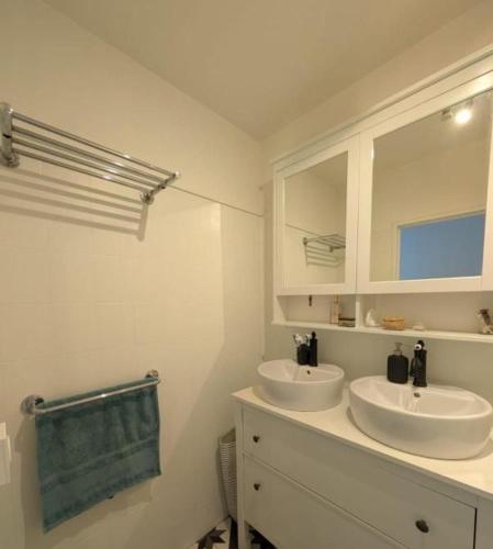 une salle de bain avec deux lavabos et un sèche-serviettes vert dans l'établissement Paris's appartement, à Gennevilliers