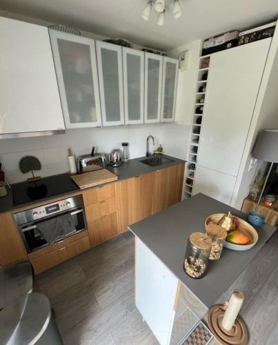 une cuisine avec des armoires blanches et un comptoir dans l'établissement Paris's appartement, à Gennevilliers