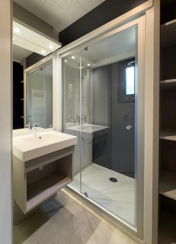 une salle de bain avec une douche en verre et un lavabo dans l'établissement Grand chalet familial, à Figeac