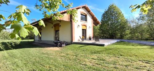 une petite maison avec une cour herbeuse devant elle dans l'établissement La hal'te verte, à Rilly-sur-Aisne