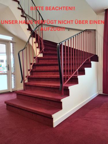 a staircase in a house with red carpet at Hotel Mühleneck in Schortens