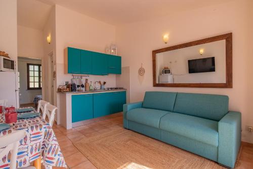 a living room with a blue couch and a kitchen at Villa del sole 4 in Capoliveri