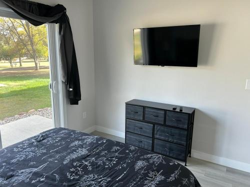 Un dormitorio con una cama y un televisor en una pared. en The Hygge House, en Spirit Lake