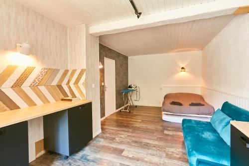 Cette petite chambre comprend un lit et un canapé bleu. dans l'établissement Joyone,appartement rénové dans maison vigneronne de 1682 avec terrasse, à Mouthier-Haute-Pierre