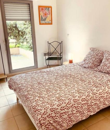 une chambre avec un lit avec une grande fenêtre dans l'établissement Appartement avec terrasse, à Nîmes