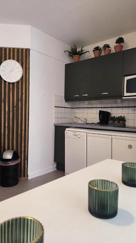 une cuisine avec des placards blancs et des tabourets verts dans l'établissement Superbe appart au golf de St Cyprien Piscine, à Saint-Cyprien