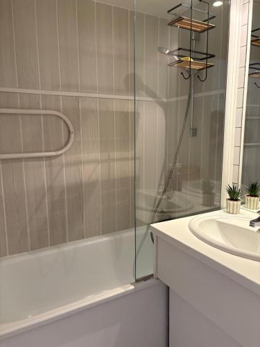 une salle de bain avec une douche en verre et un lavabo dans l'établissement Superbe appart au golf de St Cyprien Piscine, à Saint-Cyprien