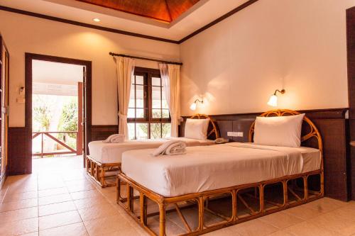 a bedroom with two beds in a room at Coco Palm Beach Resort - SHA Extra Plus in Mae Nam