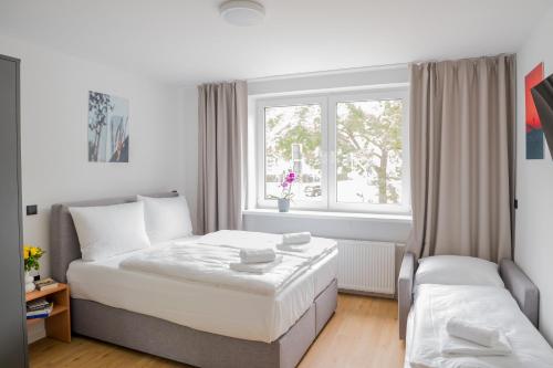 a small bedroom with a bed and a window at Homaris Apartments Nibelungen in Frankfurt/Main