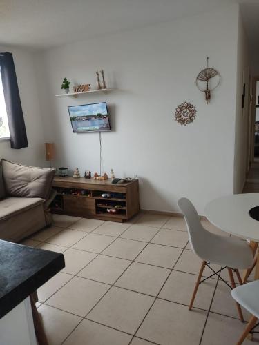 a living room with a couch and a tv at Apartamento condomínio maré d oro in Rio das Ostras