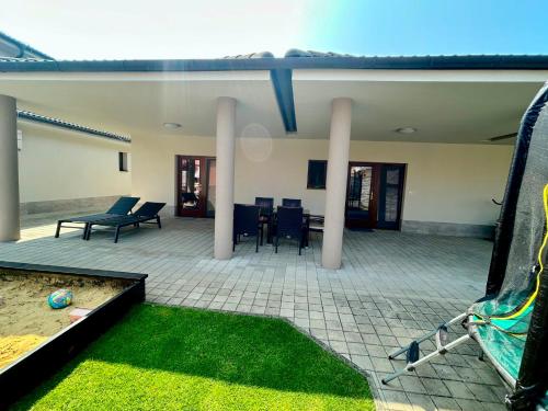un grande patio con tavolo e sedie e prato di Vila Lexus a Veľký Meder