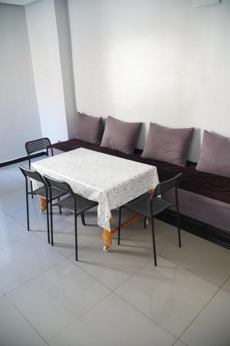 a table and chairs in a room with a couch at Le Calme a Temara in Temara