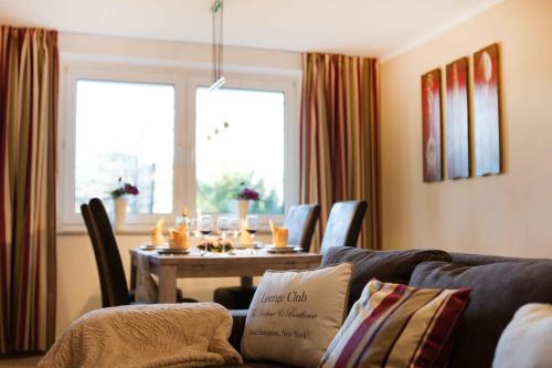 ein Wohnzimmer mit einem Sofa und einem Esstisch in der Unterkunft Ferienwohnung Butterfly in Arnstadt