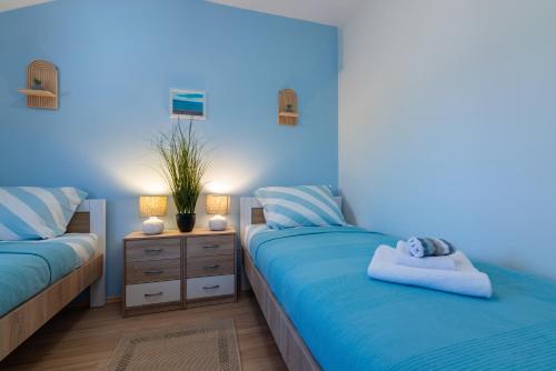 ヴァンタシチにあるVanta Vistaの青いベッドルーム(ベッド2台、ナイトスタンド付)