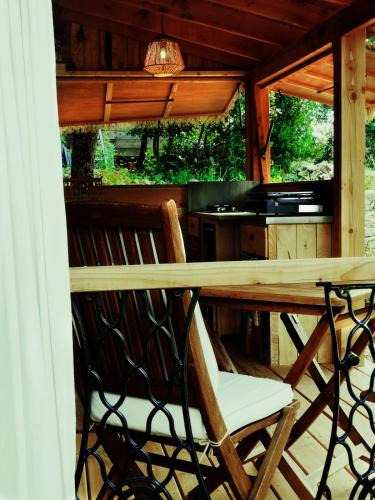 une table et des chaises en bois sur un porche dans l'établissement Gîte cosy Petit Canaillou, à Saint-André-de-Cruzières