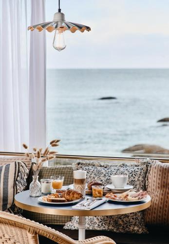 a table with food on it with a view of the ocean at Hôtel de la Mer & Spa in Brignogan-Plages