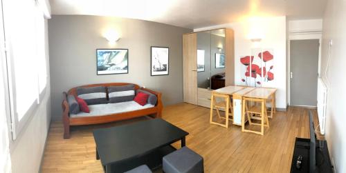 un salon avec un lit et une table dans l'établissement Grand appartement lumineux avec balcon, à Lorient