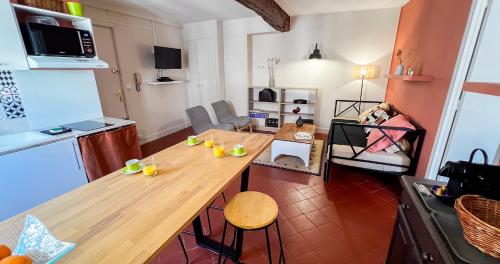 Il comprend une cuisine avec une table en bois et un salon. dans l'établissement AC - Hypercenter - Near Collection Lambert, à Avignon