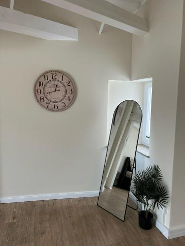 a mirror and a clock on a white wall at Alster Stay no 45 in Hamburg
