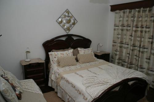 a bedroom with a large bed with pillows at Casa do Prendinha A in Ponta do Pargo