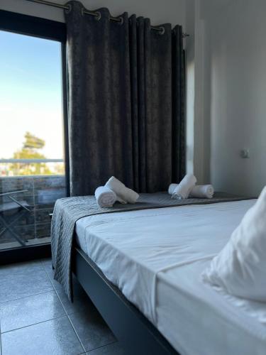 a bedroom with a bed and a window with a view at Uka apartment in Nea Iraklia