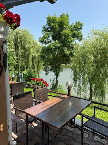 a wooden table on a patio with a view of a lake at Hotel Ciric in Iaşi