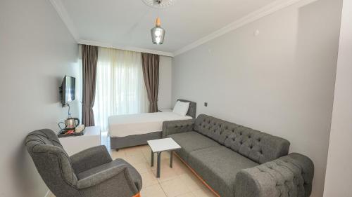 a living room with a couch and two chairs and a bed at Pineloft Selimiye in Mugla