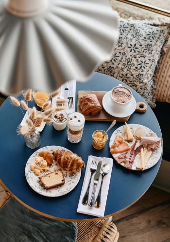 a blue table with plates of food on it at Hôtel de la Mer & Spa in Brignogan-Plages