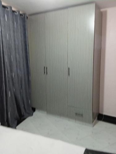 two gray cabinets in a room with a curtain at Leilani Homes in Kajiado