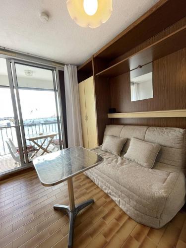 un salon avec un canapé et une table en verre dans l'établissement Studio Héliopolis F 66 - 4 personnes, au Cap d'Agde