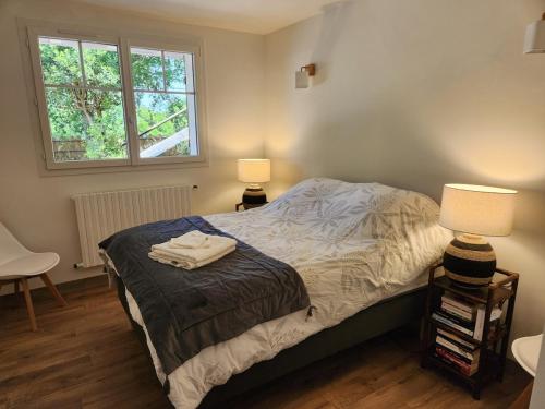 une chambre avec un lit avec deux lampes et une fenêtre dans l'établissement Appart à 100 m Arcachon Golf, à La Teste-de-Buch