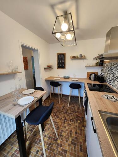 une cuisine avec deux tables et un comptoir avec des chaises dans l'établissement Appart à 100 m Arcachon Golf, à La Teste-de-Buch