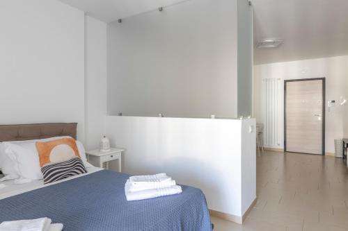 a white room with a bed with a blue blanket at Little Rose in Catania
