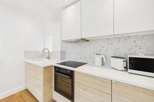 a white kitchen with a sink and a microwave at Host & Stay - The Surf Shack in Saltburn-by-the-Sea
