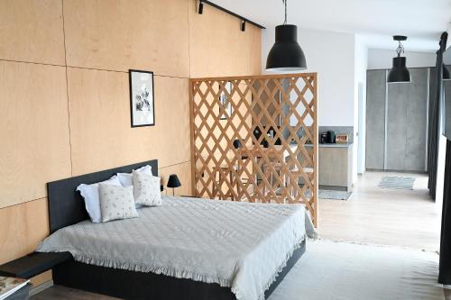 a bedroom with a bed and a wooden wall at Villa Alveare in Banya