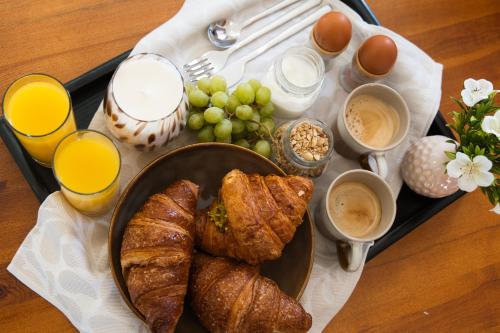 een schaal met brood en croissants en glazen sinaasappelsap bij Tenuta Poggio Piero in Montemassi