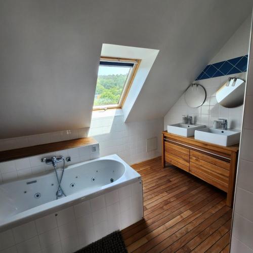 La salle de bains est pourvue d'une grande baignoire et d'un lavabo. dans l'établissement MAISON DE CAMPAGNE à LA MER pour un COUP DE COEUR, à Étretat