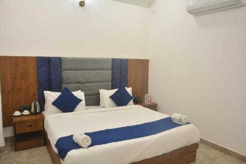 Un dormitorio con una cama grande con almohadas azules y blancas. en Hotel AU Villa-Just 2km Away From TajMahal, en Agra