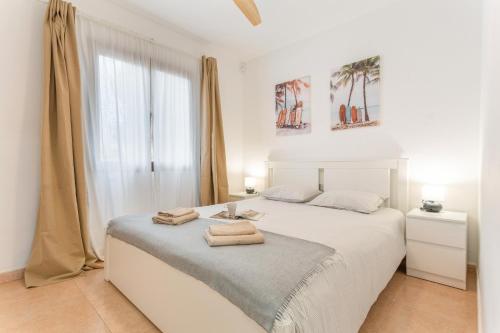 コラレホにあるCasa Loletaの白いベッドルーム(タオル付きのベッド付)