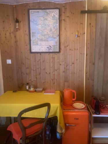 une pièce avec une table jaune et une carte au mur dans l'établissement Chambre en bois, à La Turbie