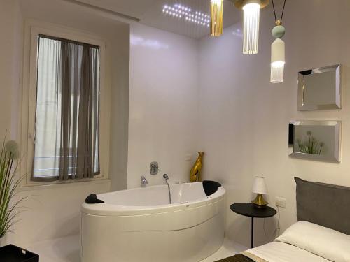 bagno bianco con vasca e letto di Ellie Luxury Apartment a Roma