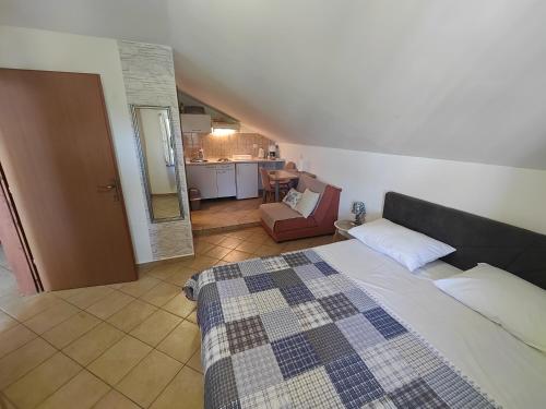 a bedroom with a bed and a chair in a room at Apartments Stana in Sukošan
