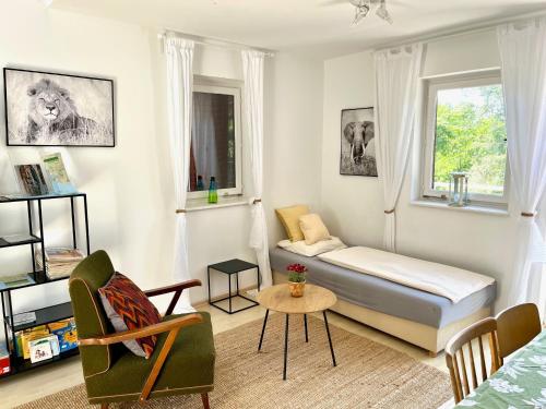 een slaapkamer met een bed, een stoel en een tafel bij Vadrózsa apartman in Badacsonytomaj