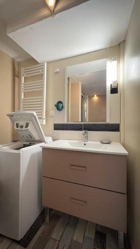 une salle de bain avec un lavabo et un miroir dans l'établissement Vieljeux, à La Rochelle