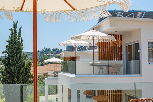 a villa with a view of a house with umbrellas at Serenity Hill in Paliouri