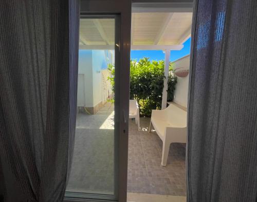 a sliding glass door to a patio with a view of a yard at LA PERLA BIANCA Apartment - Near Train Station and Best Beaches with Amazing Sunsets in Anzio