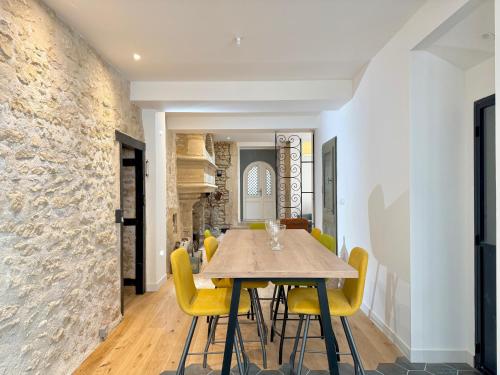 une salle à manger avec une table en bois et des chaises jaunes dans l'établissement Grand appartement centre-ville, à Poitiers