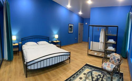 a blue bedroom with a bed and a blue wall at Mountain View in Stepantsminda