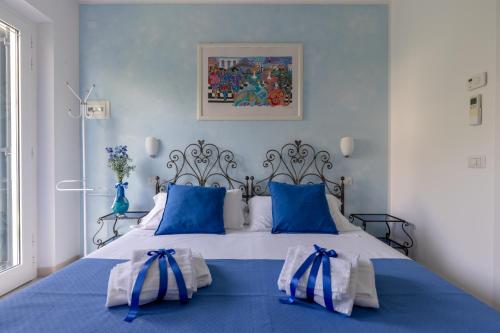 a blue bedroom with a large bed with blue pillows at Giglio Del Conero in Numana